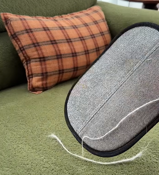 Pet hair removal glove in action on sofa